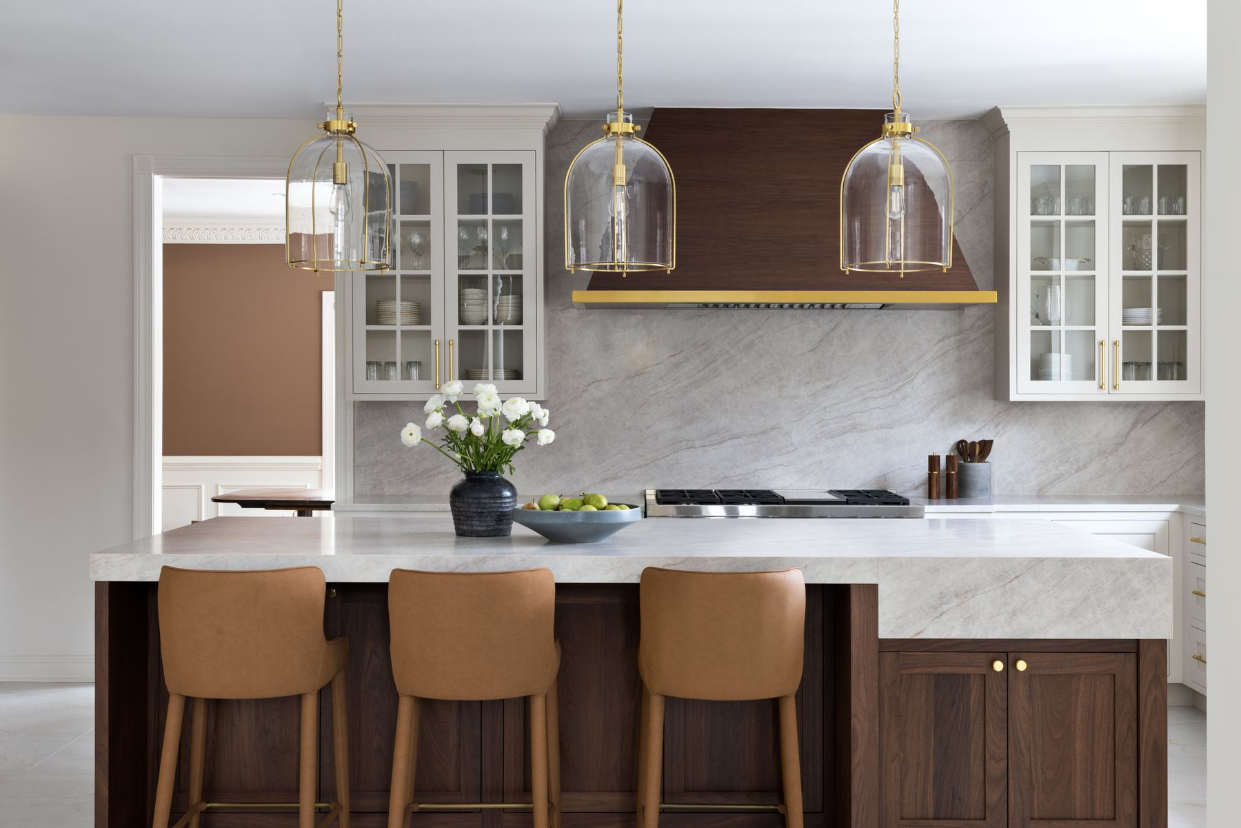 Kitchen design with marble backsplash and brass pendant lighting